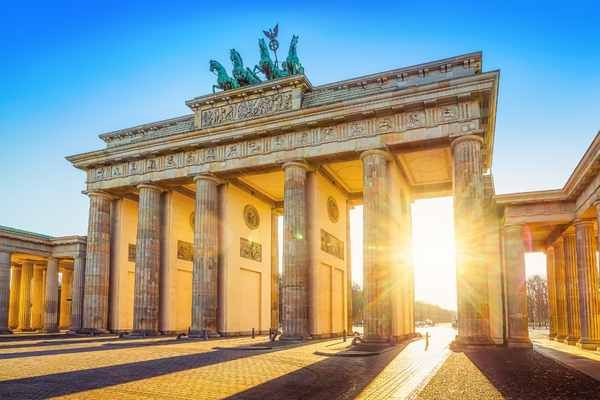Salida del sol por detrás de la puerta de Brandenburgo en Berlín